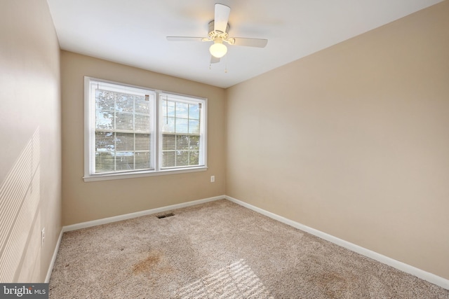 empty room featuring ceiling fan and light carpet