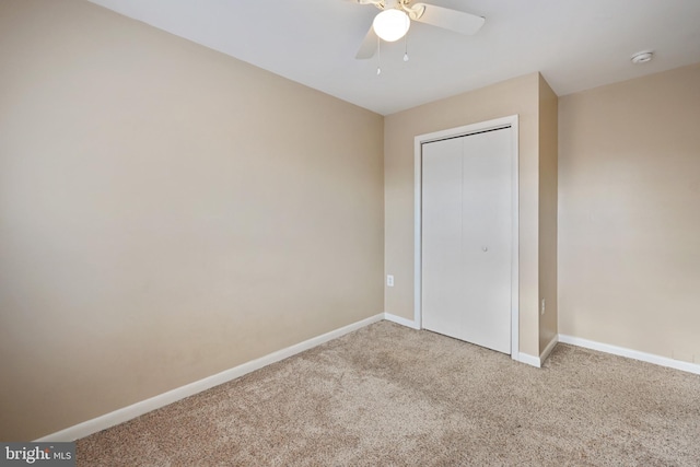 unfurnished bedroom with ceiling fan, a closet, and carpet