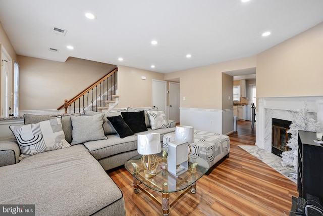 living room with light hardwood / wood-style floors, a healthy amount of sunlight, and a fireplace