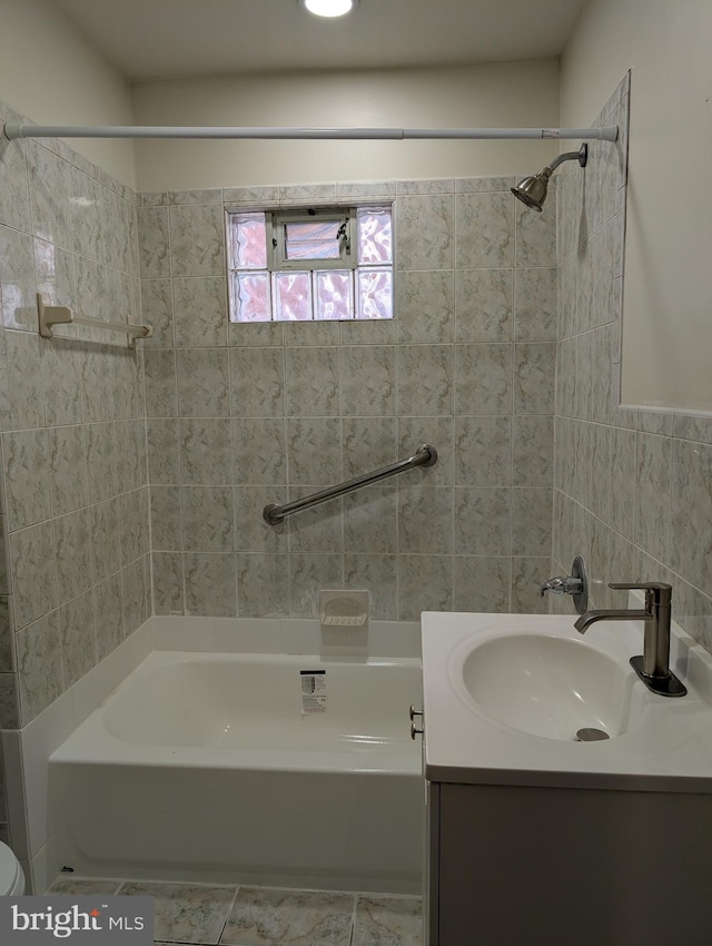 bathroom featuring vanity and tiled shower / bath