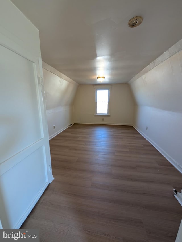 additional living space featuring hardwood / wood-style floors and vaulted ceiling