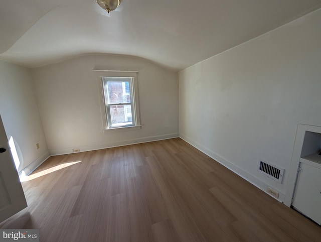 additional living space featuring lofted ceiling and light wood-type flooring