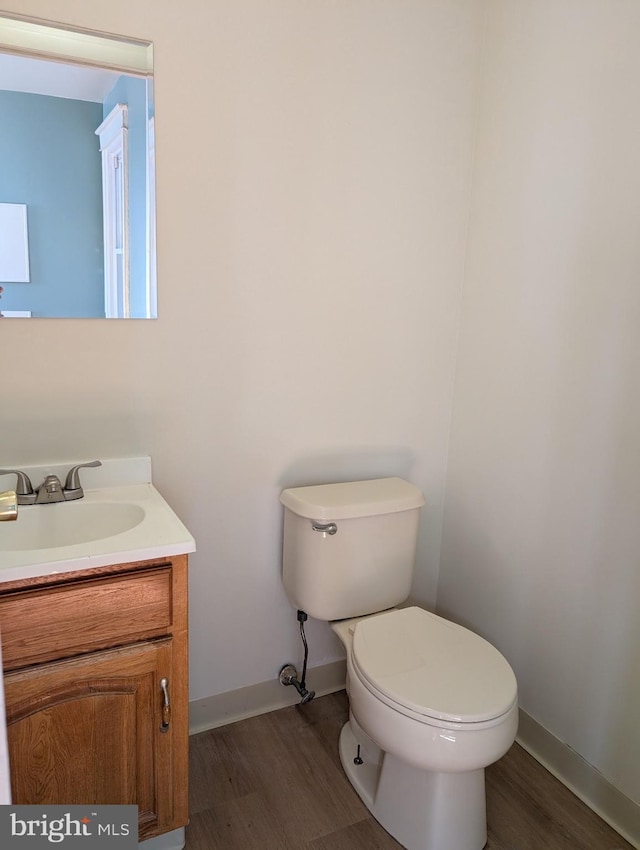 bathroom with hardwood / wood-style flooring, vanity, and toilet