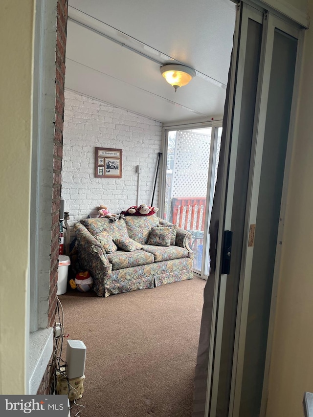 interior space with carpet and brick wall