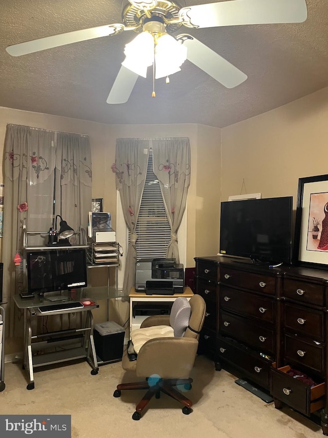 office area with ceiling fan, a textured ceiling, and light colored carpet