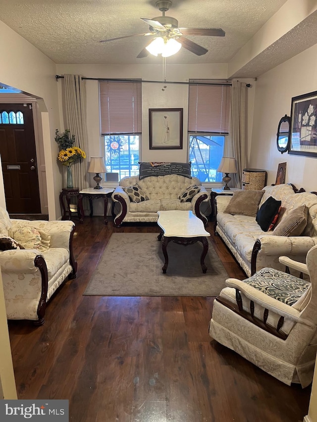 living room with a textured ceiling, plenty of natural light, ceiling fan, and dark hardwood / wood-style floors