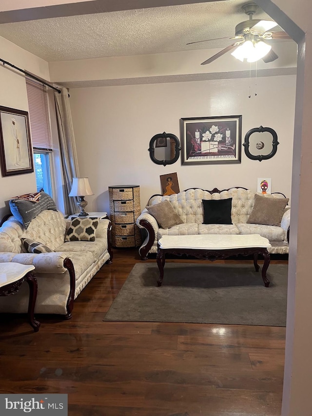 living room with a textured ceiling, dark hardwood / wood-style floors, and ceiling fan