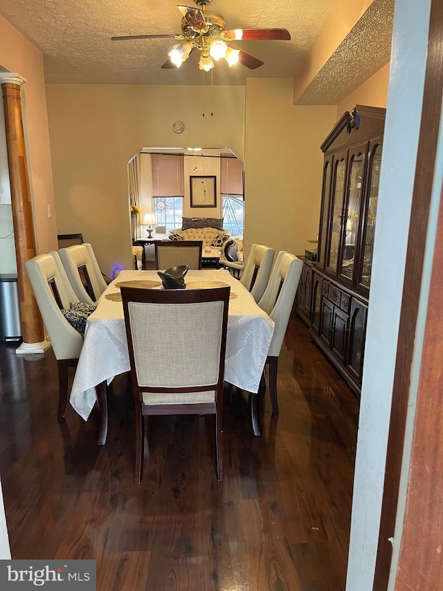 dining room with ceiling fan, dark wood-type flooring, and a textured ceiling