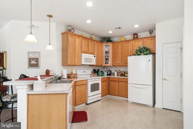 kitchen with kitchen peninsula, sink, white appliances, hanging light fixtures, and a kitchen breakfast bar