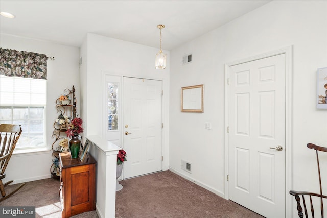 view of carpeted foyer entrance