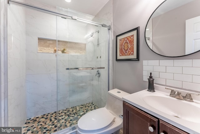 bathroom with vanity, toilet, and a shower with shower door