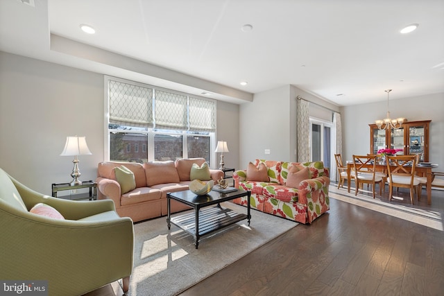 living room featuring an inviting chandelier and dark hardwood / wood-style flooring