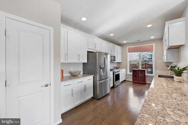 kitchen featuring white cabinetry, light stone countertops, and stainless steel appliances