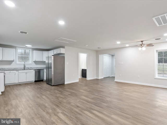 kitchen with stainless steel appliances, ceiling fan, sink, light hardwood / wood-style flooring, and white cabinetry