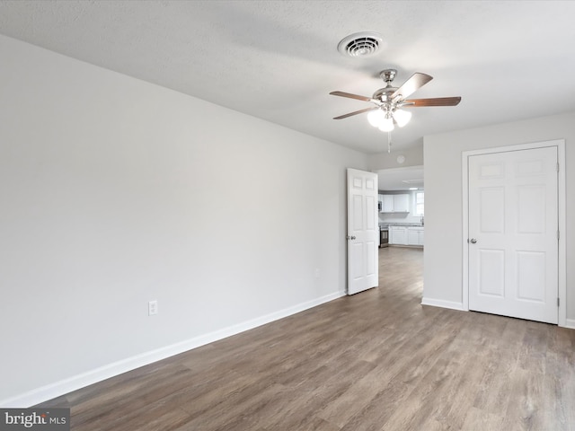 unfurnished room featuring ceiling fan, light hardwood / wood-style floors, and a textured ceiling