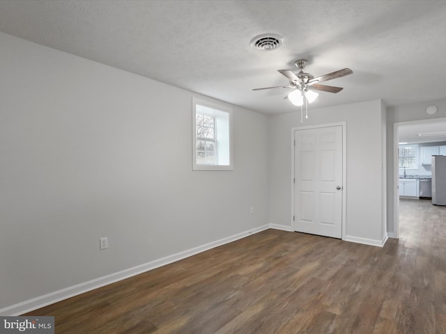 unfurnished room featuring ceiling fan, sink, a textured ceiling, and dark wood-type flooring