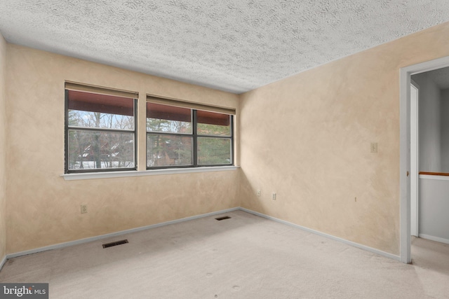 carpeted spare room featuring a textured ceiling