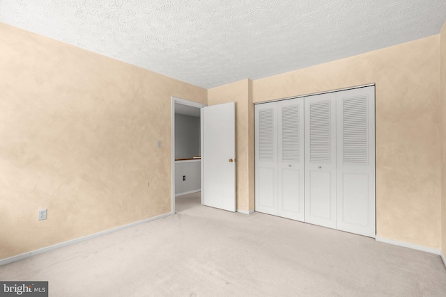 unfurnished bedroom with light carpet, a closet, and a textured ceiling