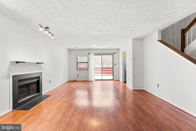 unfurnished living room featuring a textured ceiling and hardwood / wood-style flooring