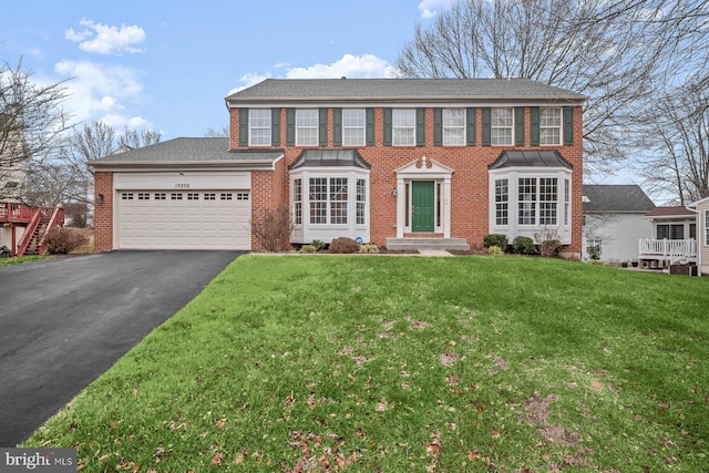 colonial home featuring a front lawn and a garage