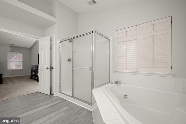 bathroom with hardwood / wood-style flooring and independent shower and bath