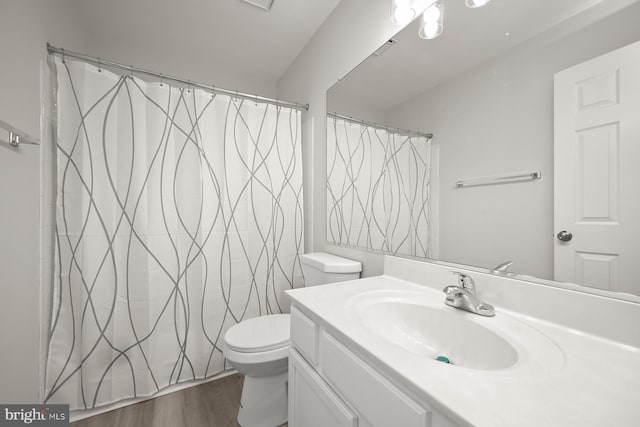 bathroom with curtained shower, hardwood / wood-style flooring, vanity, and toilet