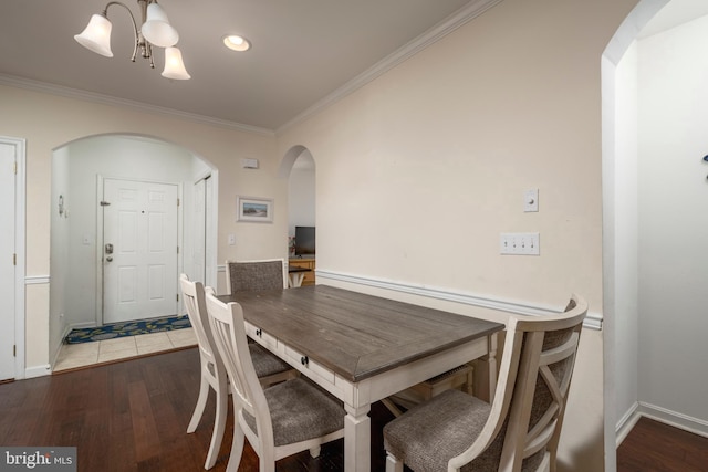 dining room featuring dark hardwood / wood-style flooring, an inviting chandelier, and crown molding