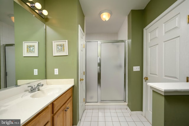 bathroom featuring tile patterned floors, vanity, and a shower with shower door