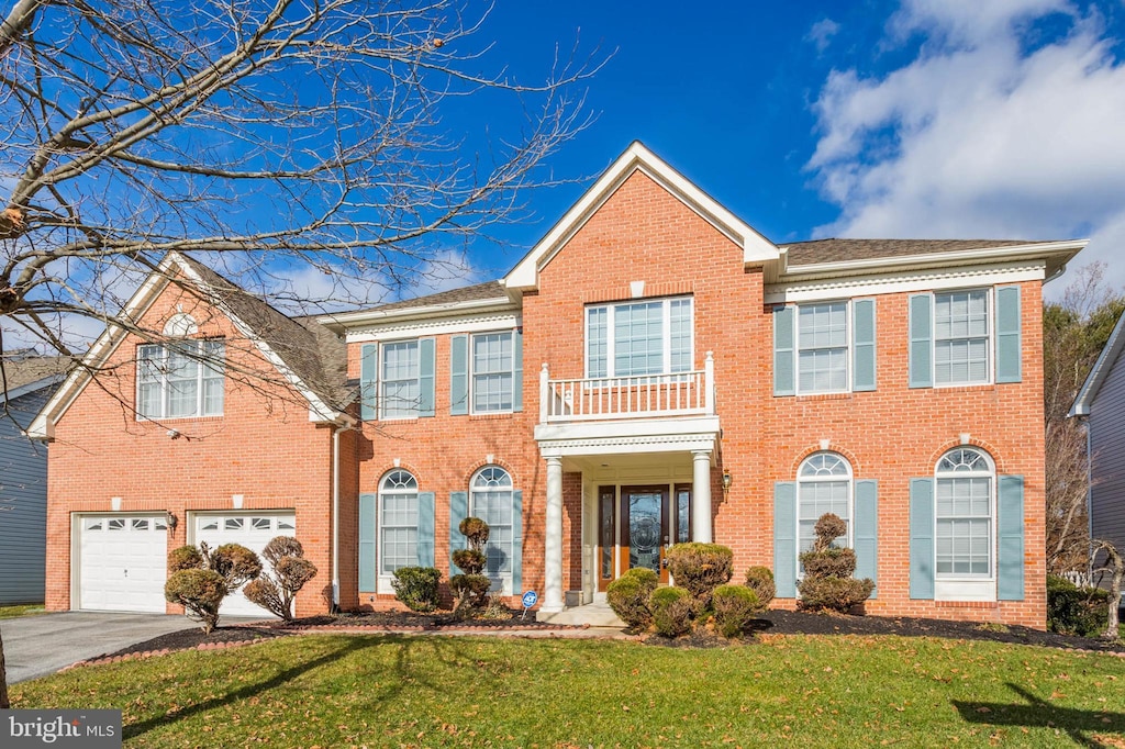 view of front of property with a balcony, a garage, and a front lawn