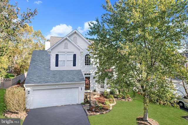 view of property featuring a garage and a front lawn