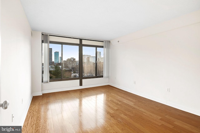 unfurnished room with hardwood / wood-style flooring