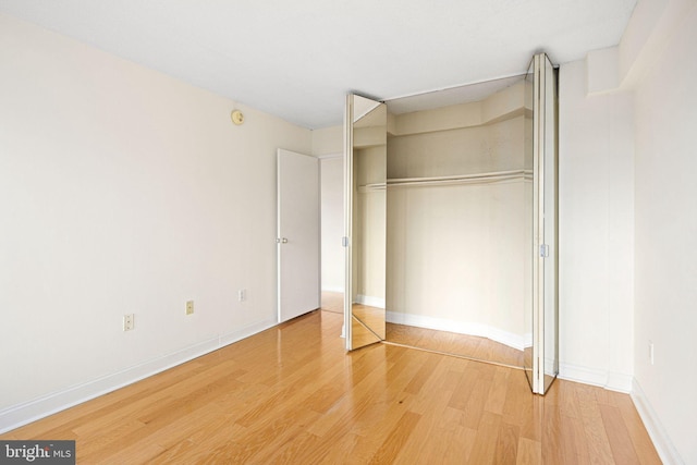 unfurnished bedroom with hardwood / wood-style floors and a closet