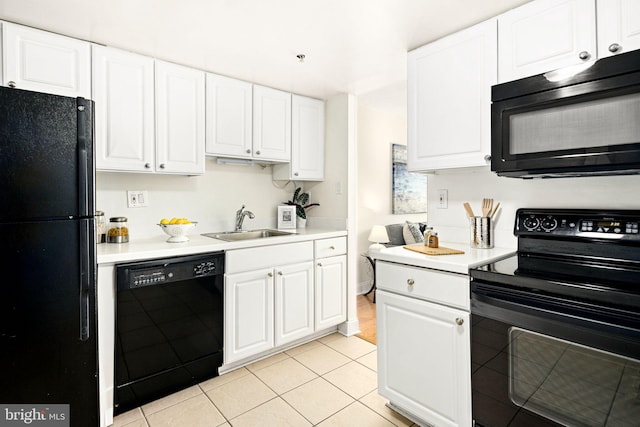 kitchen with black appliances, white cabinets, light tile patterned floors, and sink