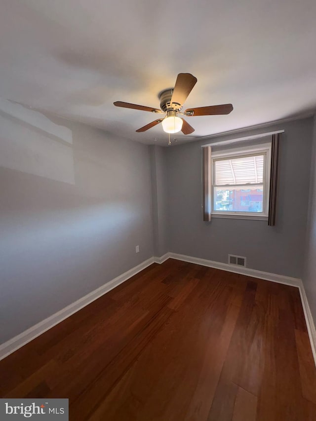 unfurnished room with ceiling fan and dark hardwood / wood-style flooring