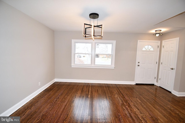 entrance foyer featuring dark hardwood / wood-style flooring and a notable chandelier