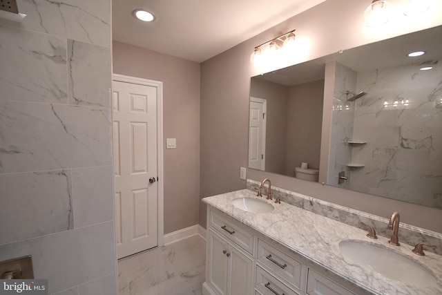 bathroom featuring tiled shower, vanity, and toilet