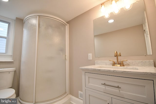 bathroom with vanity, toilet, and a shower with shower door