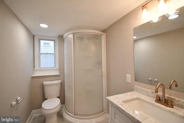 bathroom featuring vanity, a shower with shower door, and toilet