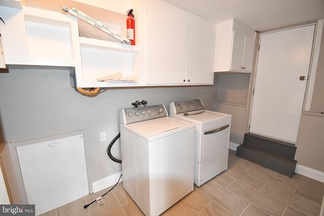 laundry room with washing machine and clothes dryer and cabinets