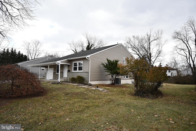 view of home's exterior featuring central AC unit, covered porch, and a yard