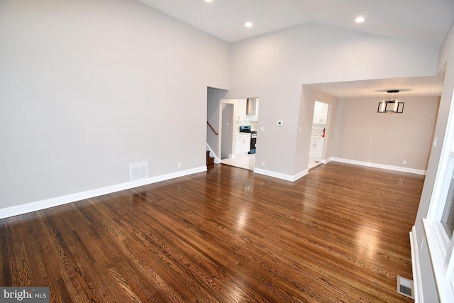 unfurnished room with dark wood-type flooring and high vaulted ceiling