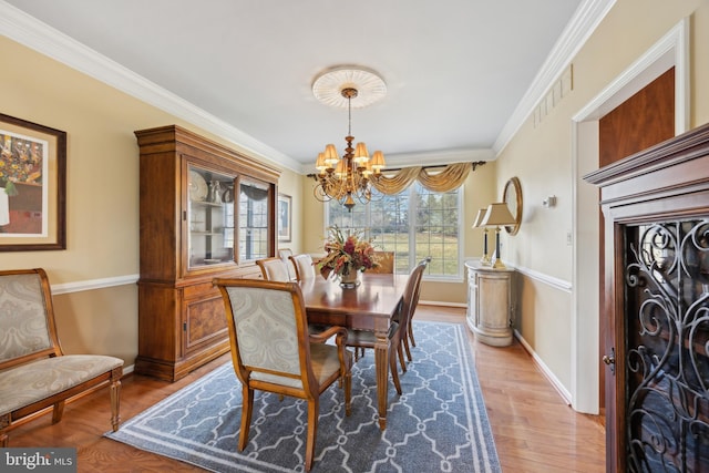 dining room featuring a chandelier, crown molding, and hardwood / wood-style floors