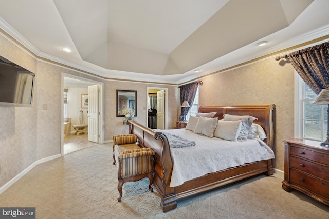 bedroom featuring ensuite bathroom, a raised ceiling, a walk in closet, and multiple windows