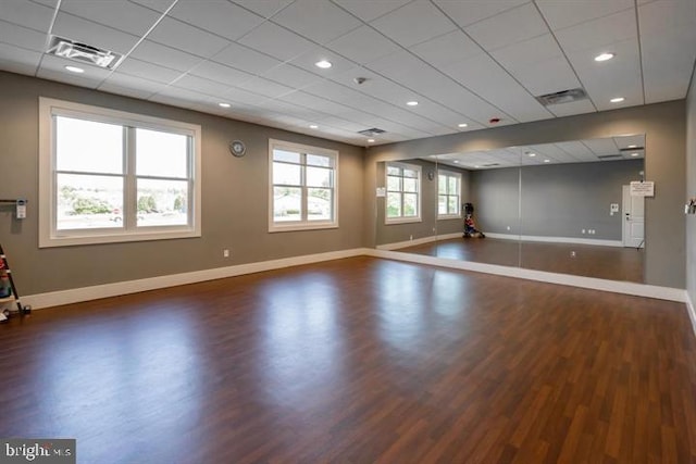 exercise area with dark wood-type flooring and a paneled ceiling