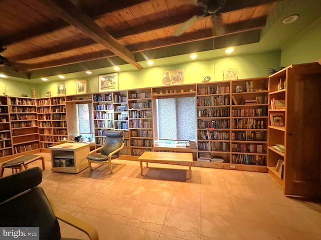 living area featuring beam ceiling, wood ceiling, and ceiling fan