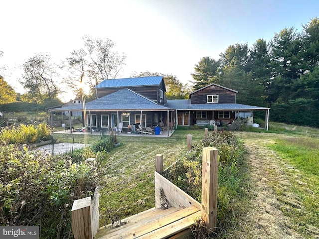 rear view of house with a patio and a lawn