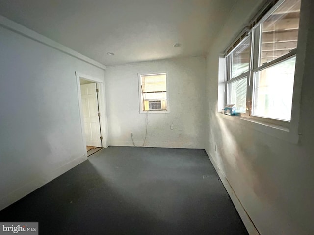 unfurnished room featuring cooling unit and concrete floors