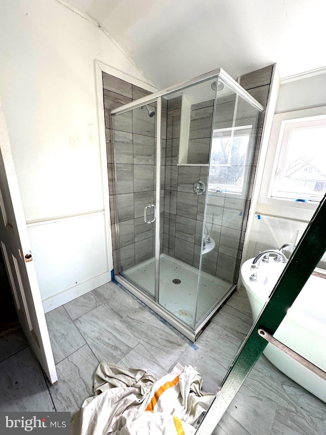 bathroom featuring vaulted ceiling and a shower with door