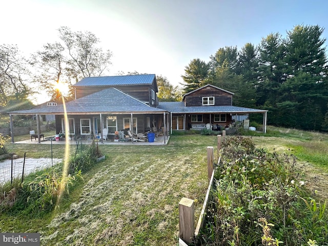 rear view of property with a yard and a patio area