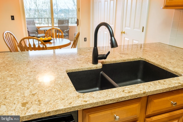 kitchen with light stone countertops and sink